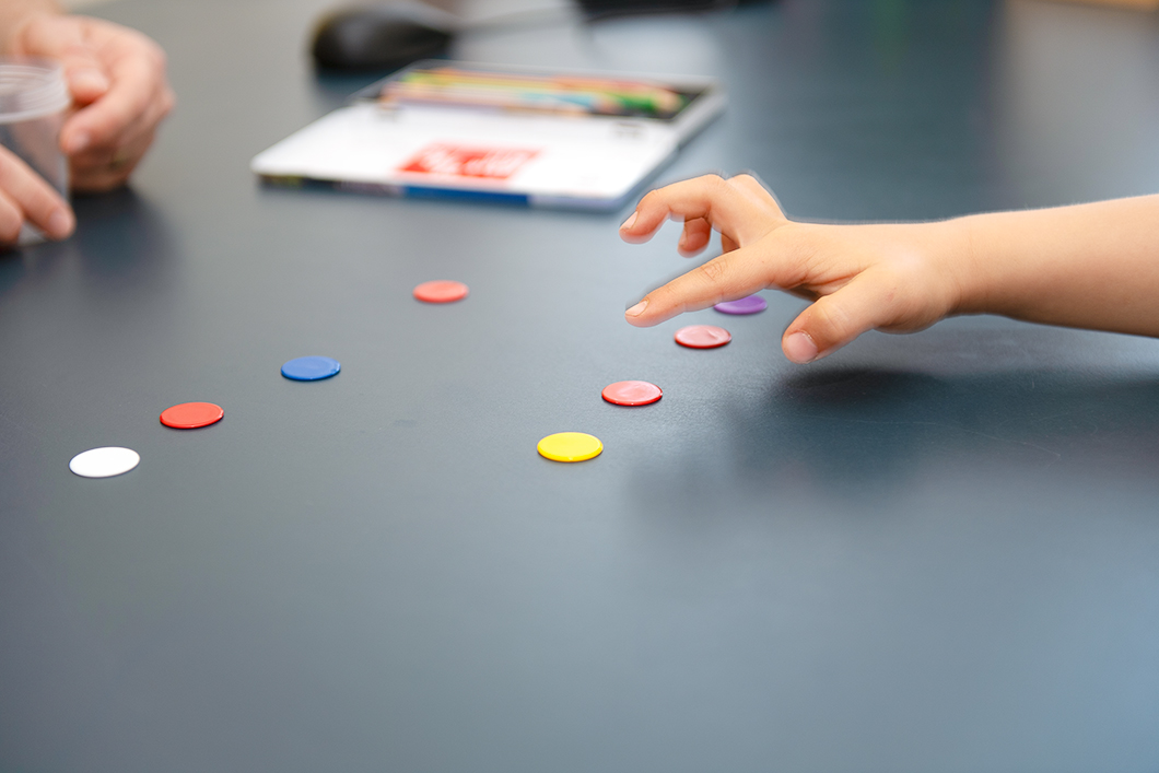 Vorsorge-Untersuchung Ein Kind zeigt auf farbige Buttons