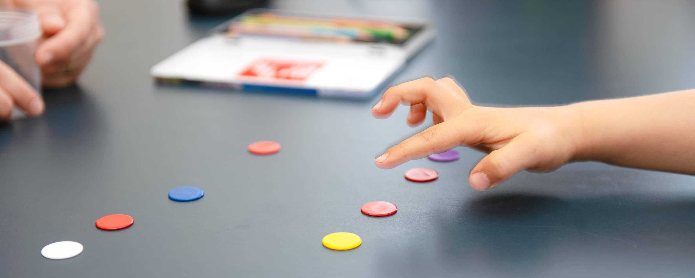 Ein Kind zeigt auf farbige Buttons